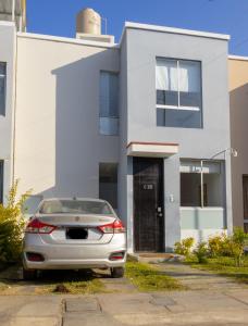 a car parked in front of a white house at Don Checho's House in Ica