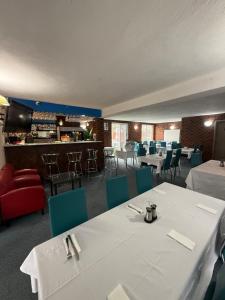 a restaurant with white tables and chairs and a bar at Zero Inn Motel in Nhill