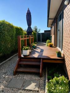 a wooden patio with potted plants and an umbrella at Bellarine Breeze in Drysdale +2 photos