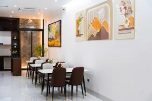 a dining room with tables and chairs and paintings on the wall at CELINA HOTEL Ninh Bình in Ninh Binh