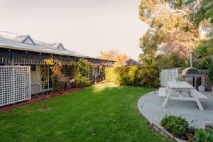 a backyard with a picnic table and a bench at Lanterns Retreat in Dunsborough