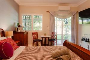 a bedroom with a bed and a table and chairs at Lanterns Retreat in Dunsborough