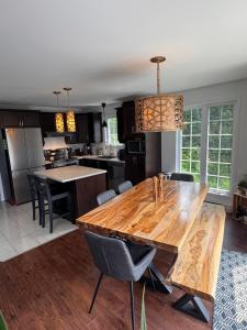 a kitchen with a wooden table and a dining room at Night Sky Cottage in Saint-Joachim