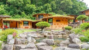 a garden with rocks in front of a building at Mungyeong Between Mountains Pet Pension in Mungyeong