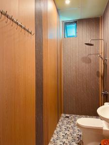 a bathroom with a shower with a toilet and a sink at Homestay CÂY THỊ in Tây Ninh