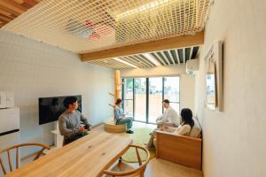 a group of people sitting in a room at YOUR ROOM treehouse KUMAMOTO in Kumamoto