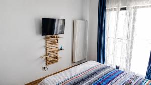 a bedroom with a bed and a television on a wall at Sea Ray Studio in Năvodari