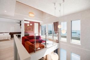 a living room with a red couch and a bed at Verda Rico in Awaji