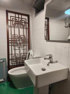 a bathroom with a white sink and a toilet at Hanok Stay Ohneul in Gyeongju +59 photos