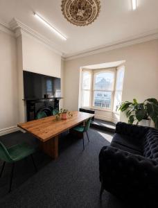a living room with a wooden table and a couch at Brunsi Hostel in Melbourne