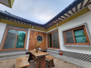a patio of a house with a table and benches at Hanok Stay Ohneul in Gyeongju