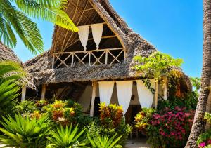 a resort with flowers in front of it at Kita Ocean House in Kiwengwa