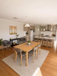 a kitchen and living room with a wooden table and chairs at Bellarine Breeze in Drysdale