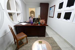 a woman sitting at a desk in a room at Carters Rest Guesthouse in Kimberley