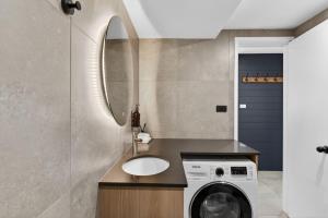a bathroom with a sink and a washing machine at Tyrola 11 in Thredbo +24 photos