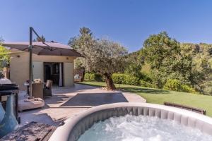a backyard with a hot tub in a garden at Maisonnette climatisée in Aix-en-Provence