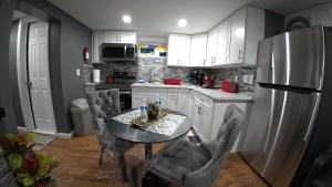 a kitchen with a table with chairs and a refrigerator at Cozy Private Two Bedroom Basement Apartment in Hempstead