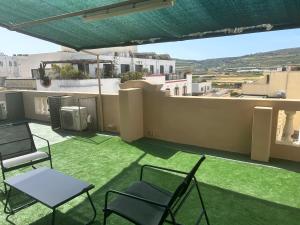 a balcony with chairs and a view of a city at Flat 3 in Mġarr