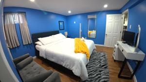 a blue bedroom with a bed and a television at Cozy Private Two Bedroom Basement Apartment in Hempstead
