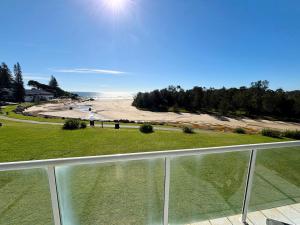 a view of the beach from the balcony of a house at Ocean Shores Apartment 14 - Bring your own linen. in South West Rocks