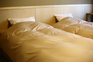 two unmade beds sitting next to each other at Nakajimaya Ryokan in Nozawa Onsen