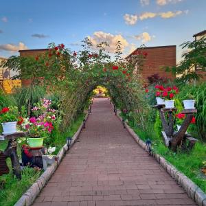 an archway in a garden with flowers on it at къщички Поляните in Sinemorets