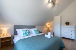 a bedroom with a blue bed with two pillows at Ostoja Lubiatowo in Lubiatowo