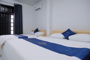 a couple of beds in a room at Happy Sun Hotel in Mỹ Tho