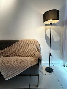 a lamp sitting next to a bed with a blanket at Taiping Centre Point Suite 7 by BWC in Taiping +29 photos