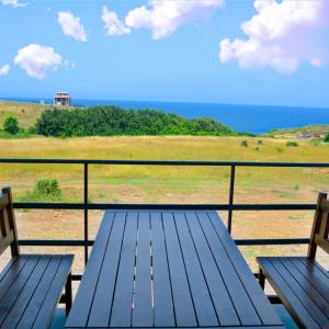 two benches on a balcony with a view of the ocean at къщички Поляните in Sinemorets
