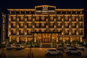 a hotel with cars parked in a parking lot at Hotel Park Green Suites Delhi Airport in New Delhi
