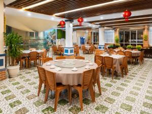 a restaurant with tables and chairs in a room at CCT Luxury Hotel in Nha Trang