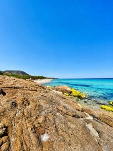 a view of the ocean from a rocky beach at VR-Room in Forte Village