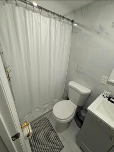 a bathroom with a white shower curtain and a toilet at Cozy Private Two Bedroom Basement Apartment in Hempstead +38 photos