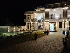 a large white house at night with a pool at Panorama Safari Villa in Trincomalee