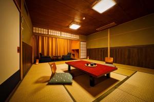 a room with a red table and a chair at Ooedo Onsen Monogatari Dogo in Matsuyama