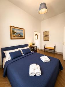 a bedroom with a blue bed with towels on it at Fattoria Barca Colonna in Orbetello +38 photos