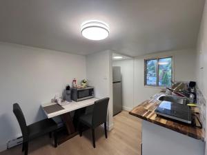 a kitchen with a table with a microwave and a sink at Stampeder Inn in Williams Lake