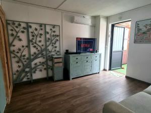 a living room with a tv on top of a dresser at Studio Maison à Saint-Denis in Saint-Denis