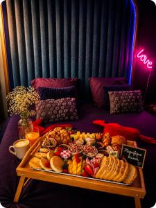 a tray of food on a table in a room at Love Room 85 avec Jacuzzi & Terrasse Privé in Kortrijk