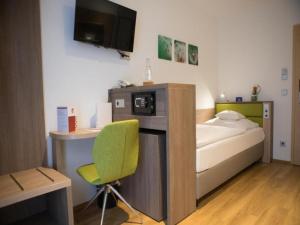 a room with a bed and a desk and a chair at Wolfsburg Sandkamp Hotel by Belvilla in Wolfsburg +28 photos