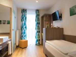 a small bedroom with a bed and a window at Wolfsburg Sandkamp Hotel by Belvilla in Wolfsburg