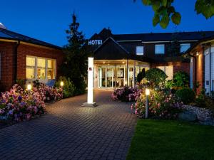 a hotel with flowers in front of a building at Wolfsburg Sandkamp Hotel by Belvilla in Wolfsburg