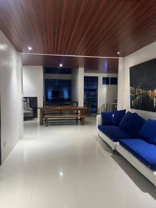 a living room with a blue couch and a wooden ceiling at Rosa Executive Residence in heart of Ormoc City in Ormoc