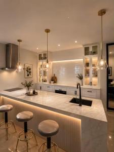 a kitchen with a counter with stools and a sink at Rosa Executive Residence in heart of Ormoc City in Ormoc