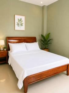 a bedroom with a large bed with white sheets at Rosa Executive Residence in heart of Ormoc City in Ormoc