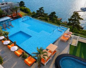 an overhead view of a large swimming pool with orange chairs at Latterace Resort in Yeosu