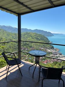 a table and chairs on a balcony with a view of the ocean at Panorama Sarpi 2 in Batumi