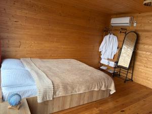 a bedroom with a bed in a wooden wall at Panorama Sarpi 2 in Batumi