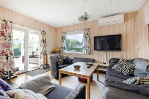 a living room with couches and a tv at Cozy Cottage At Tuse Næs In Holbæk in Holbæk